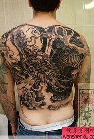 tattoo umjetnik za tetoviranje vraća natrag zmaj djeluje kao tetovaža