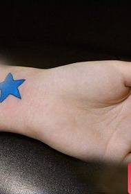 女の子の腕の美しい色の小さな五point星の入れ墨のパターン
