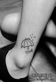 picior de fată cu un model de tatuaj umbrelă mică