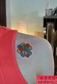 malé barevné čtyřlístkové tetování na rameni dívky