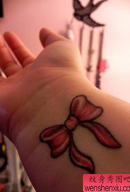 pola tato busur kecil di pergelangan tangan gadis itu