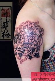 Japonski umetnik za tetoviranje na rokah deluje s krizantemami