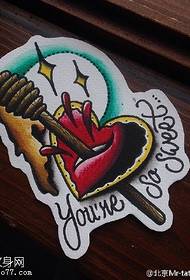 Rukopis trilera sa strelicom kroz uzorak tetovaže na srcu