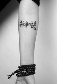 black and white Tibetan arm tattoo