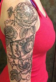 Girl's right arm flower camera tattoo