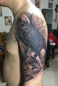 mustavalkoinen käsivarren tatuointikuva kalmarilla ja lootuksella