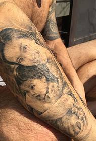 Slika tetovaže portreta supruge i kćeri na ruci