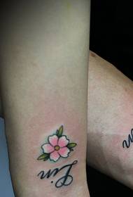 small cherry blossoms with simple English arm couple tattoo tattoo